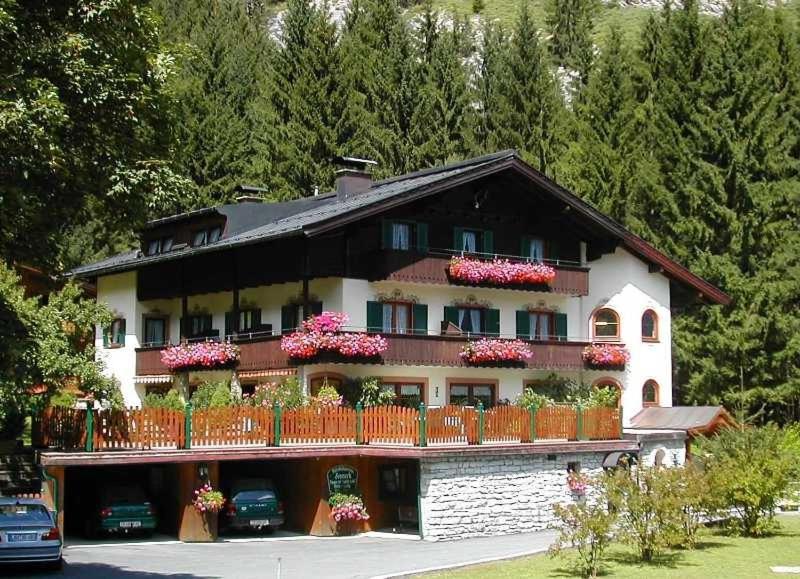 a large house with flowers on the balconies of it at Pension Sonneck in Lofer
