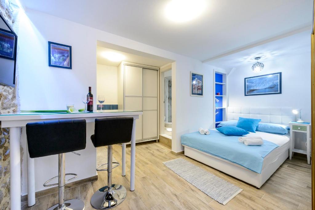 杜布羅夫尼克的住宿－格洛里亞公寓，一间卧室配有一张床和一张带椅子的桌子