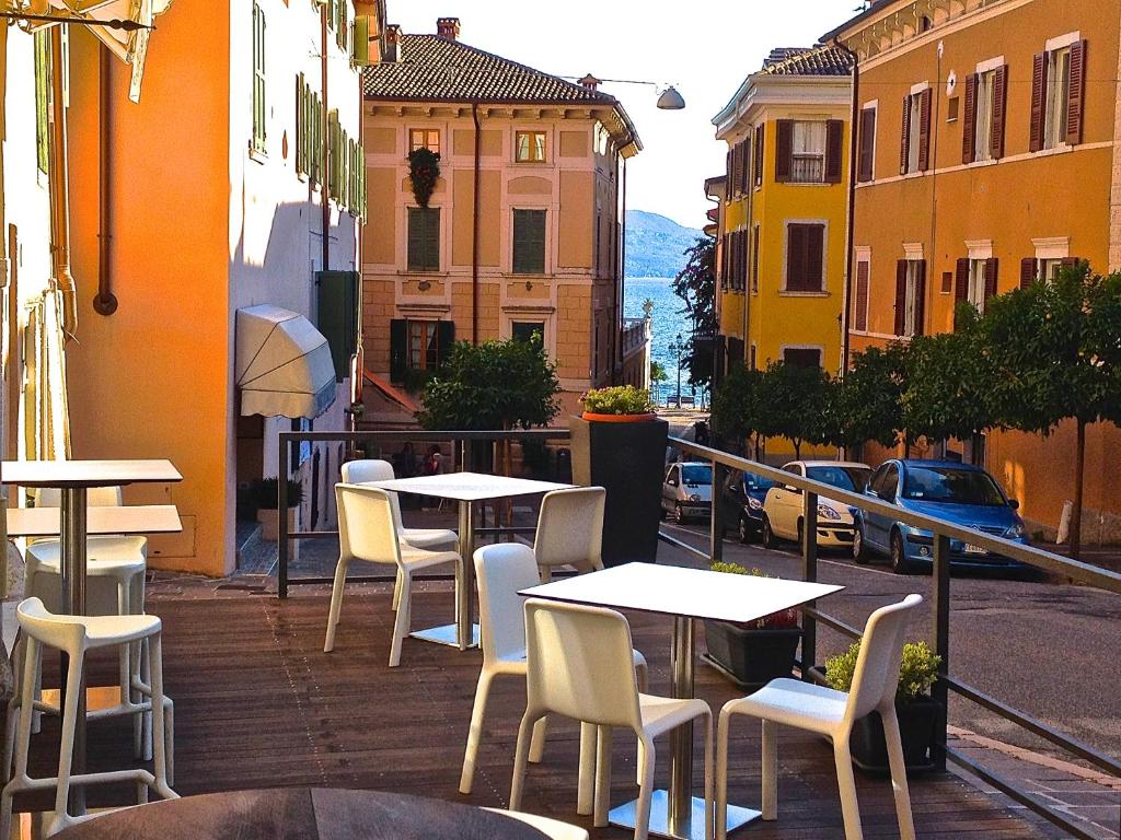 a group of tables and chairs on a city street at B&B San Rocco in Gargnano