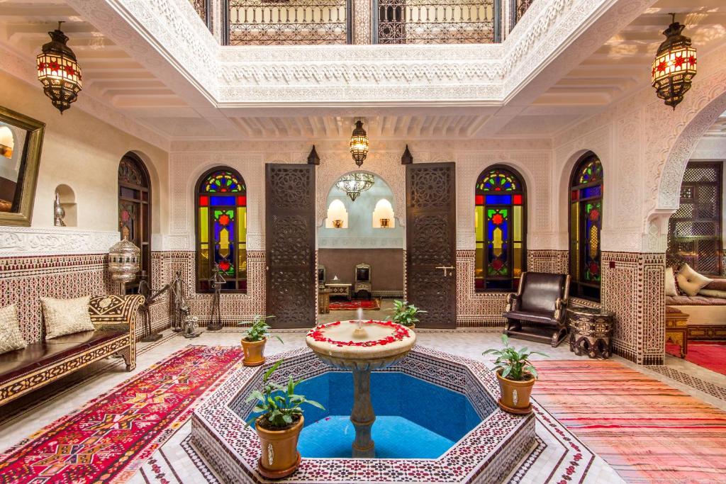 un soggiorno con piscina al centro di un edificio di Riad Lamya Marrakech a Marrakech