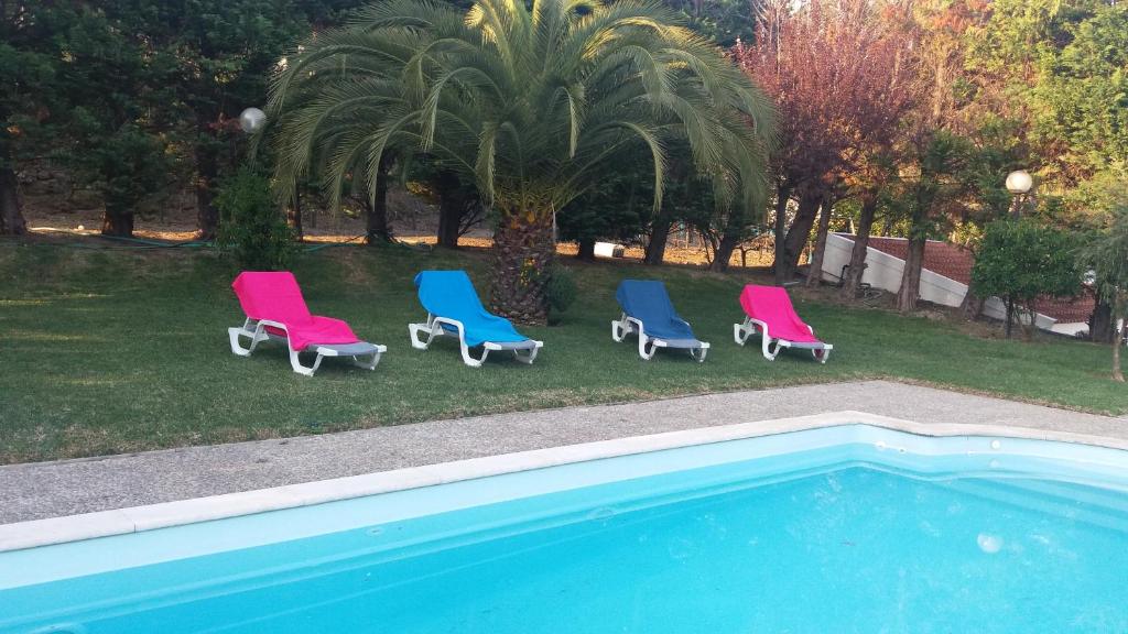 um grupo de cadeiras sentadas ao lado de uma piscina em Quinta do Salgueiral em Peso da Régua