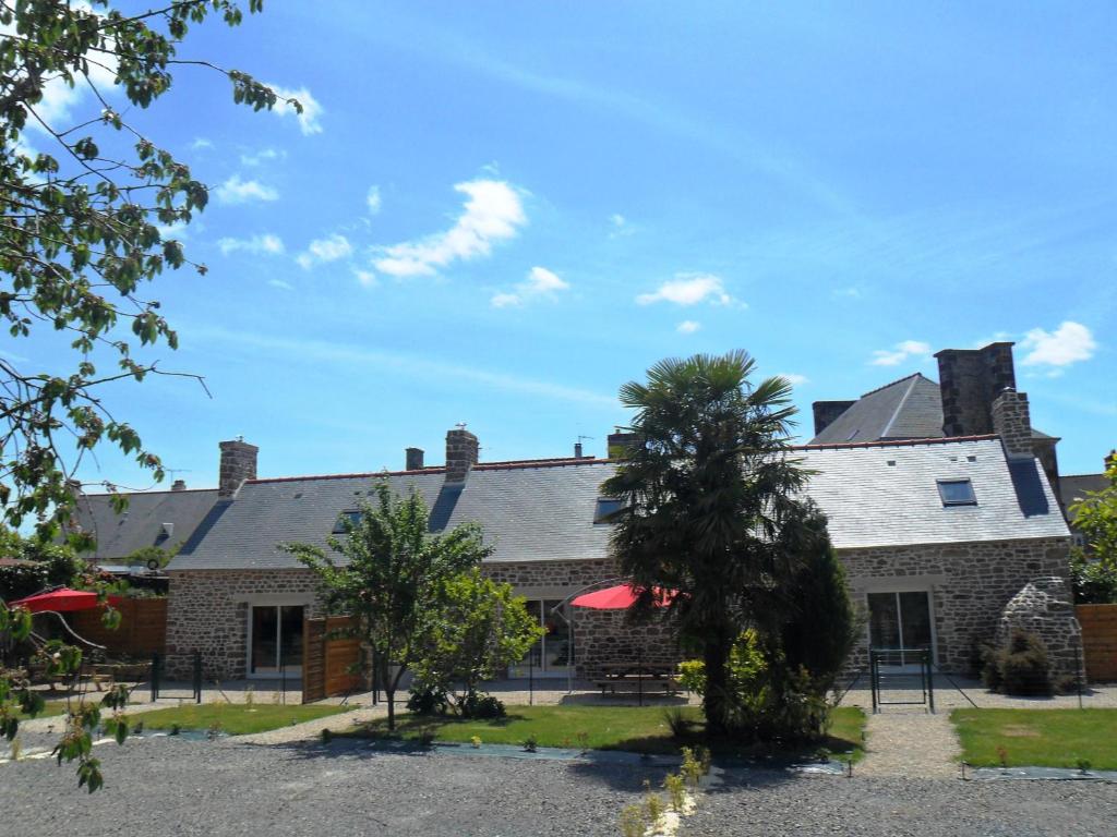 an exterior view of a large brick house with trees at Gites Mont Saint Michel "AUCOEURDELABAIE" in Sains