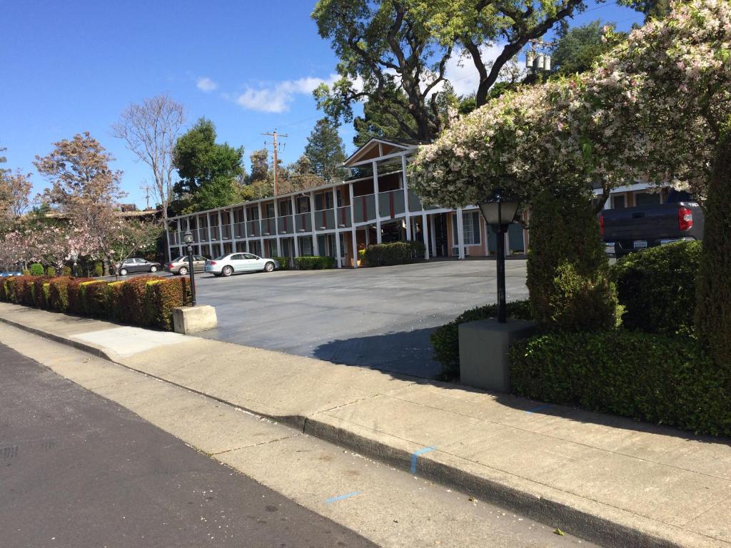 una calle frente a un edificio con aparcamiento en Oak Motel, en Palo Alto