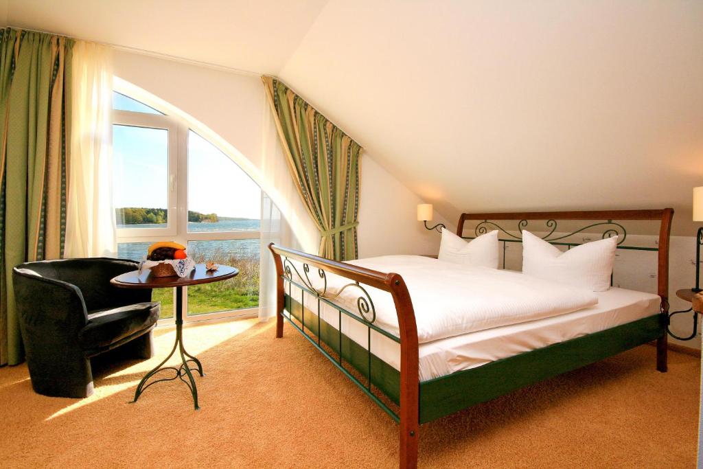 a bedroom with a bed and a chair and a window at Hotel Nautilus in Putbus