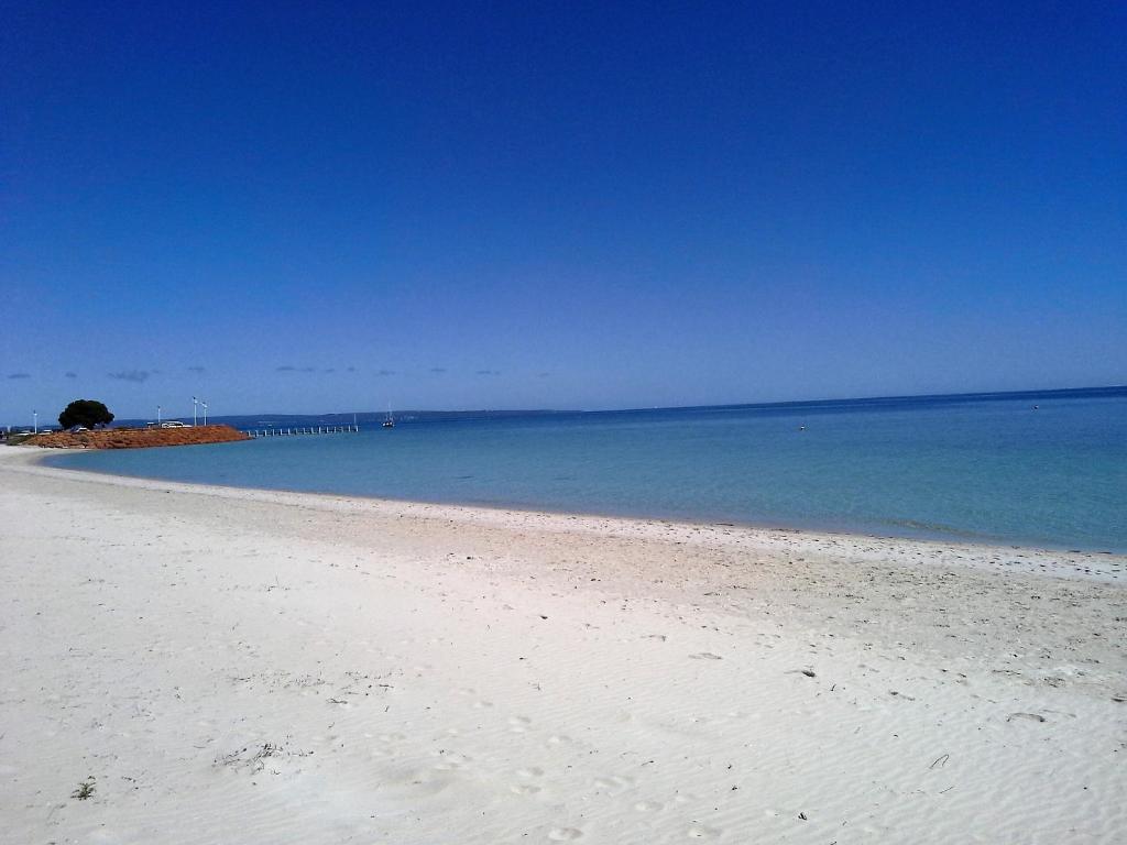 einen weißen Strand mit dem Ozean im Hintergrund in der Unterkunft Busselton Beachfront in Busselton