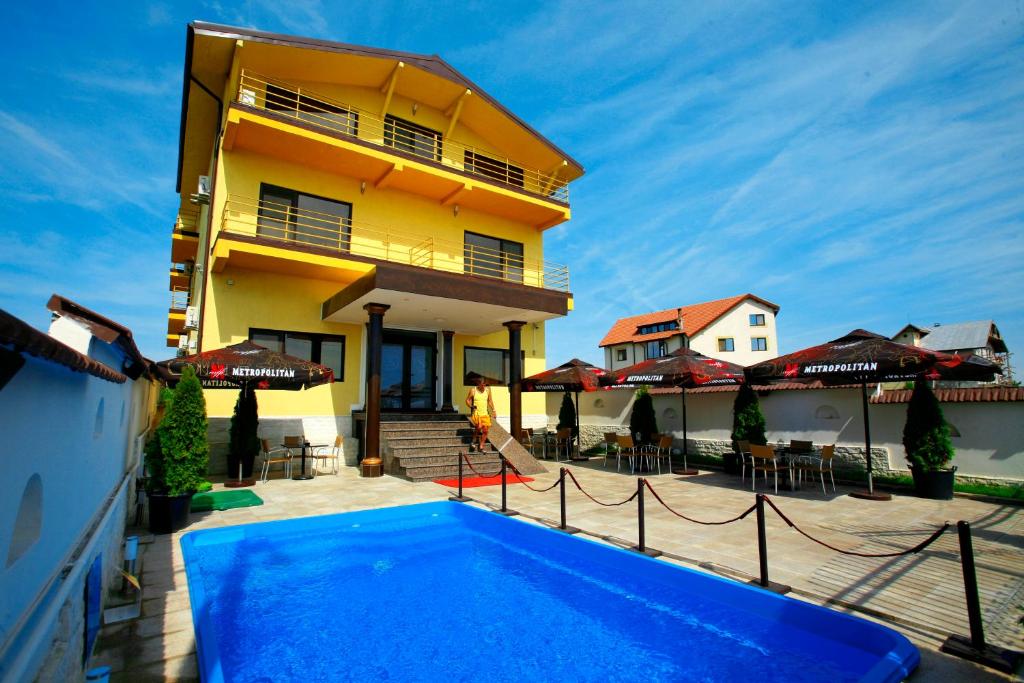 a house with a swimming pool in front of a building at Pension Siera in Mamaia Sat/Năvodari