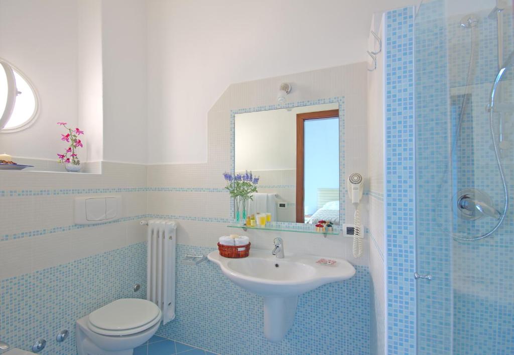a bathroom with a sink and a toilet and a mirror at Iris Hotel in Ischia