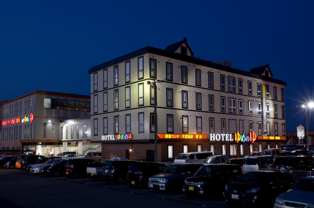 a large building with cars parked in a parking lot at Natural SPA, Kanazawa Hotel Yumenoyu in Kanazawa