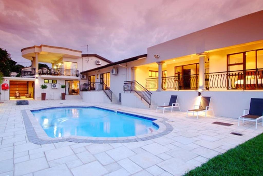 een huis met een zwembad in een tuin bij Sanchia Luxury Guest House in Durban