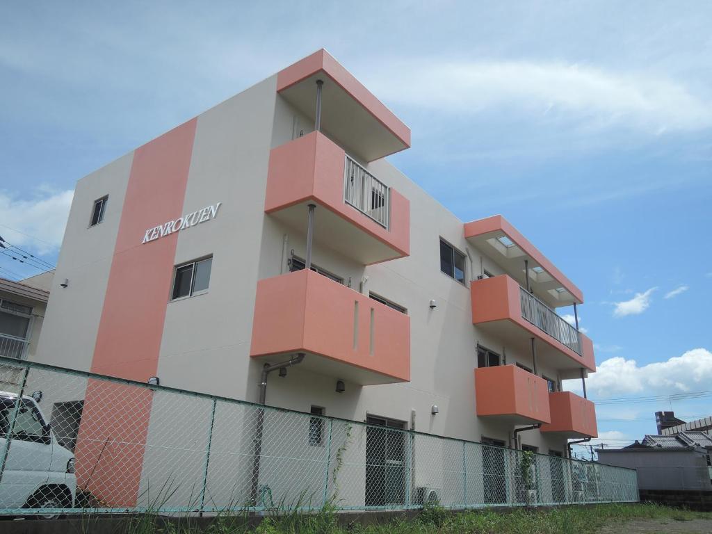 un bâtiment avec des balcons orange sur son côté dans l'établissement Kenrokuen Inn, à Nobeoka