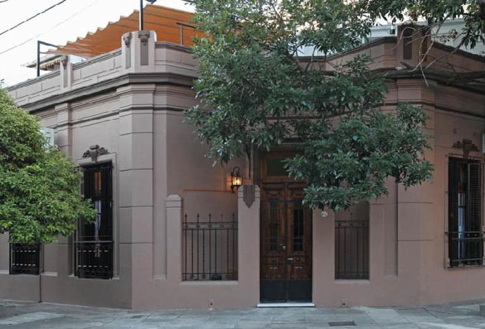 un bâtiment rose avec une porte devant lui dans l'établissement Casabierta, à Buenos Aires