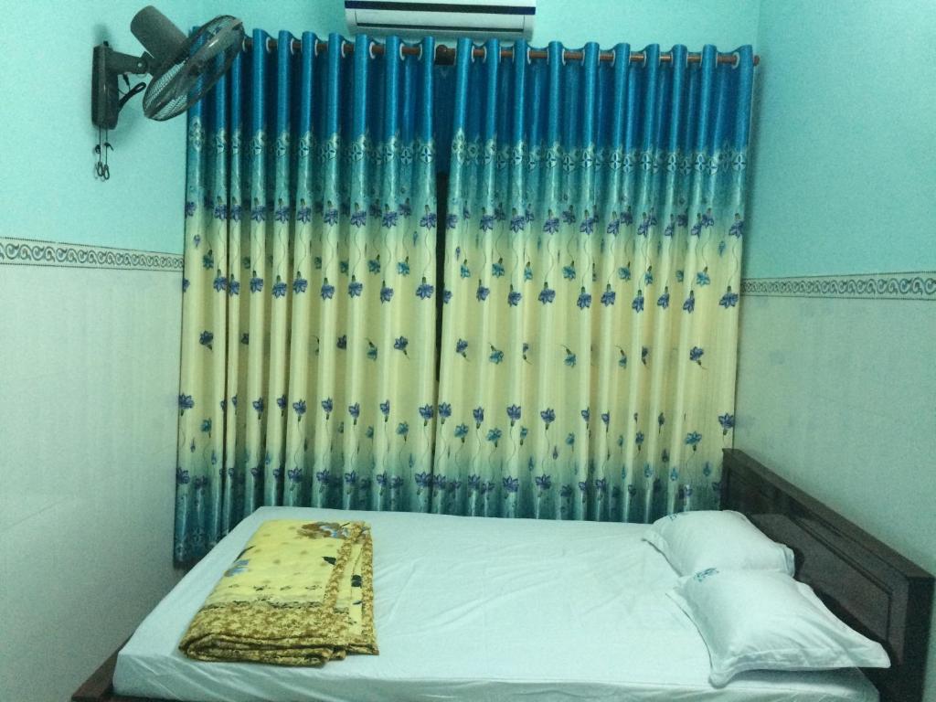 um quarto com uma cama com uma cortina e uma janela em HOTEL Thành Nam em Long Hai