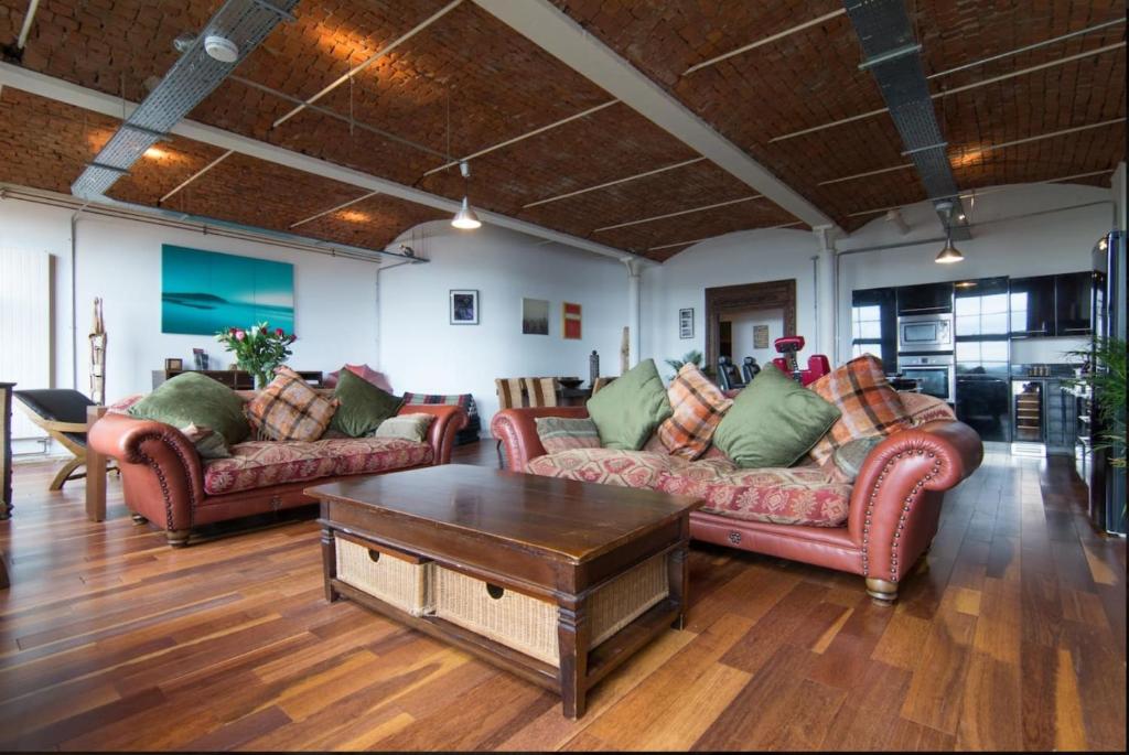 a living room with two couches and a coffee table at Loft Apartment in Port Glasgow