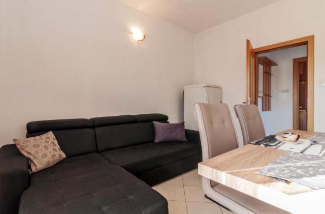 salon z czarną kanapą i stołem w obiekcie Apartments Andrej w mieście Zadar