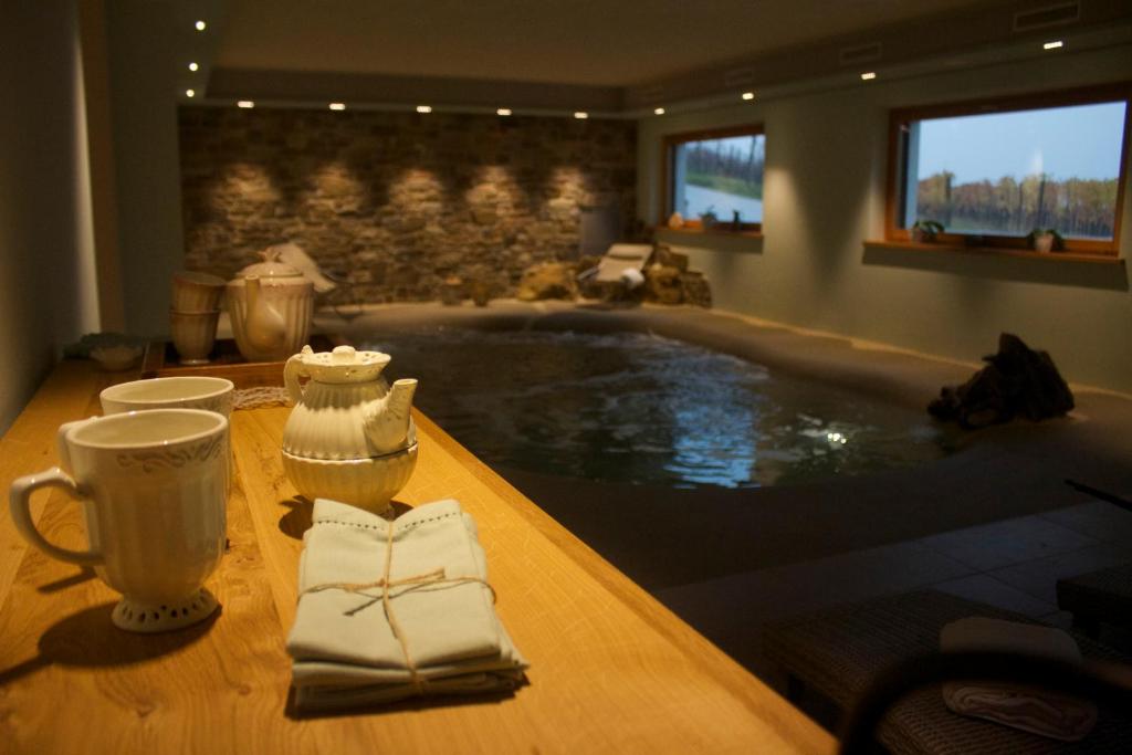 una bañera de hidromasaje en una habitación con una mesa y toallas en Gigante Wine & Welcome, en Corno di Rosazzo