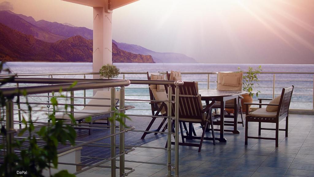 a table and chairs on a balcony with a view of the water at Gonis Suites in Palaiochóra