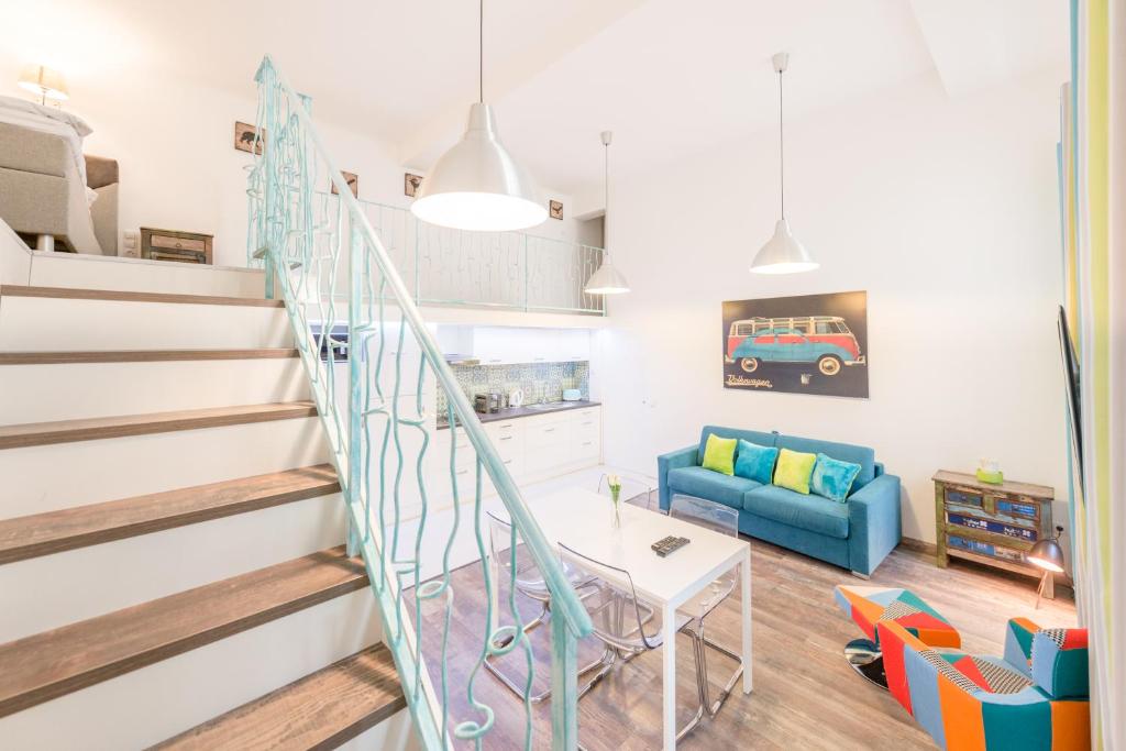 - un salon avec un escalier et un canapé bleu dans l'établissement Tamara Apartman, à Budapest