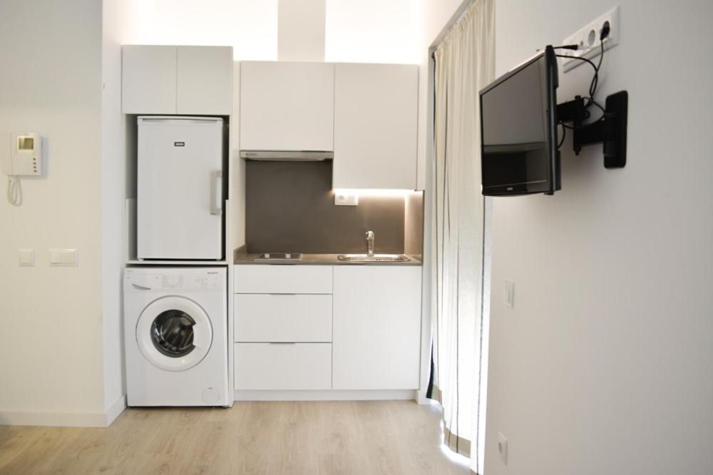 a kitchen with a refrigerator, microwave, sink and dishwasher at Apartamentos San Agustín in Murcia