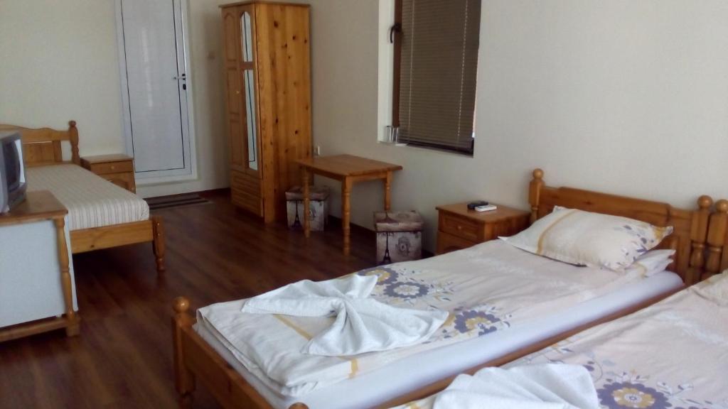 a bedroom with two twin beds and a television at Guest House Diamant in Sozopol