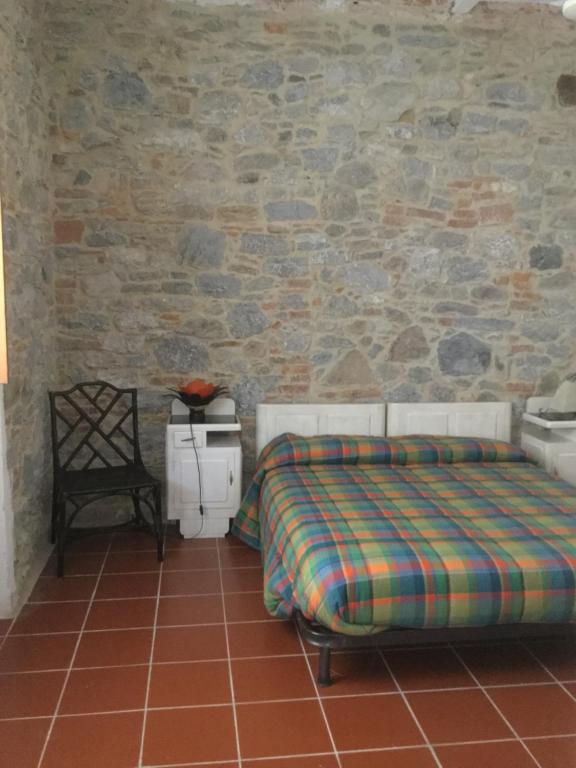 a bedroom with a bed and a stone wall at Appartamento Al Tiglio in Lucca