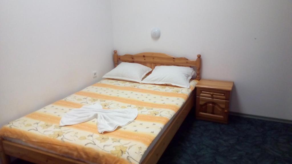 a bedroom with a bed with a wooden frame and a night stand at Guest House Diamant in Sozopol
