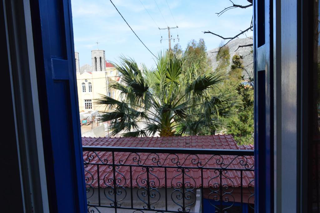 a view of a palm tree from a window at "STELIOS & GALINI" in Symi