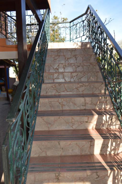 a set of stairs with a metal railing at "STELIOS & GALINI" in Symi
