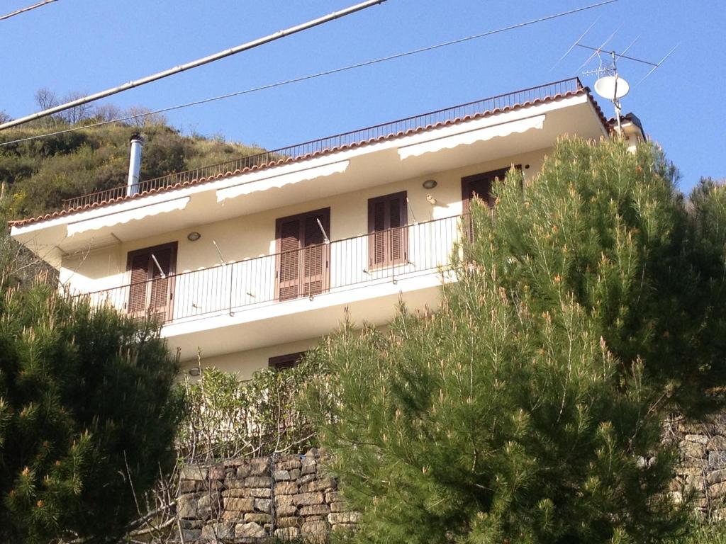 una casa blanca en la cima de una colina con árboles en Villa Espina, en Serramezzana