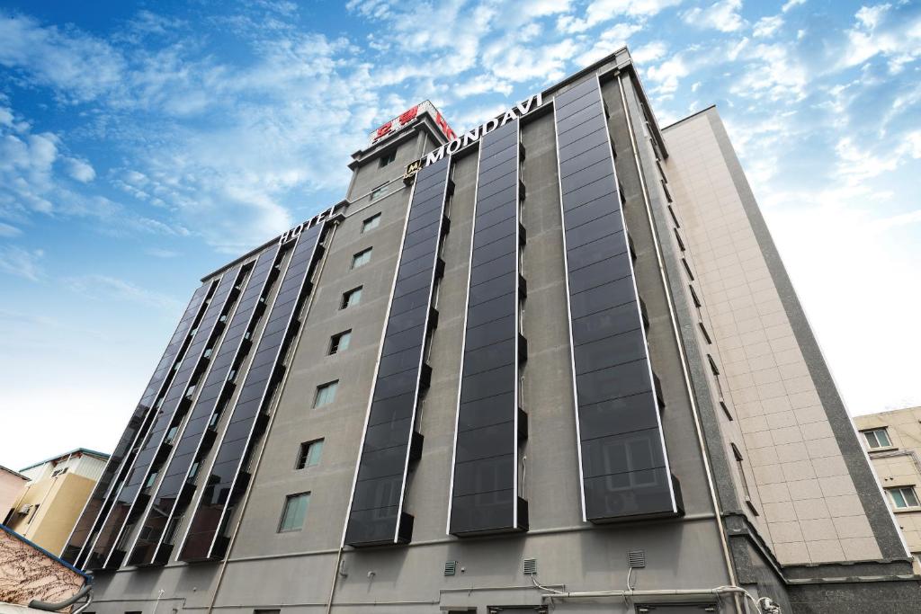 un edificio alto con un cartel encima en Hotel Mondavi en Mokpo