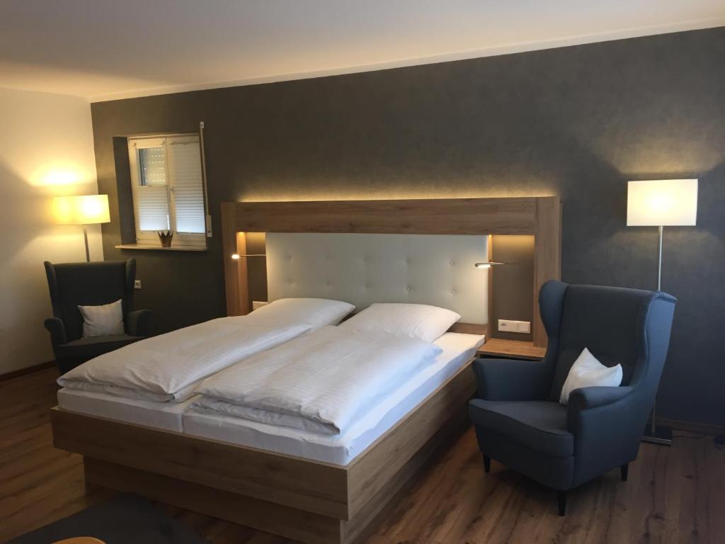 een slaapkamer met een groot bed en een blauwe stoel bij Hotel Restaurant Am Kring in Vreden