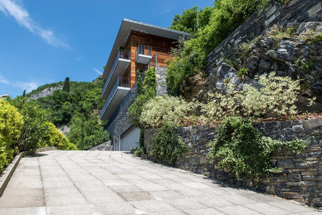 a house on the side of a stone wall at Residenza Luigina in Varenna