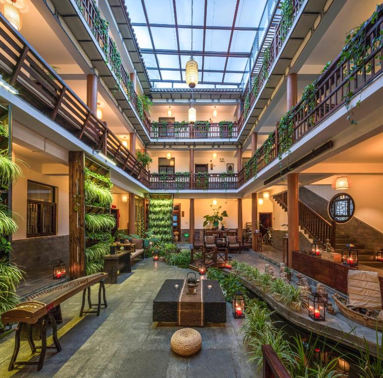 an indoor lobby with plants and tables and benches at Dali Yanyuan Mountain Retreat in Dali