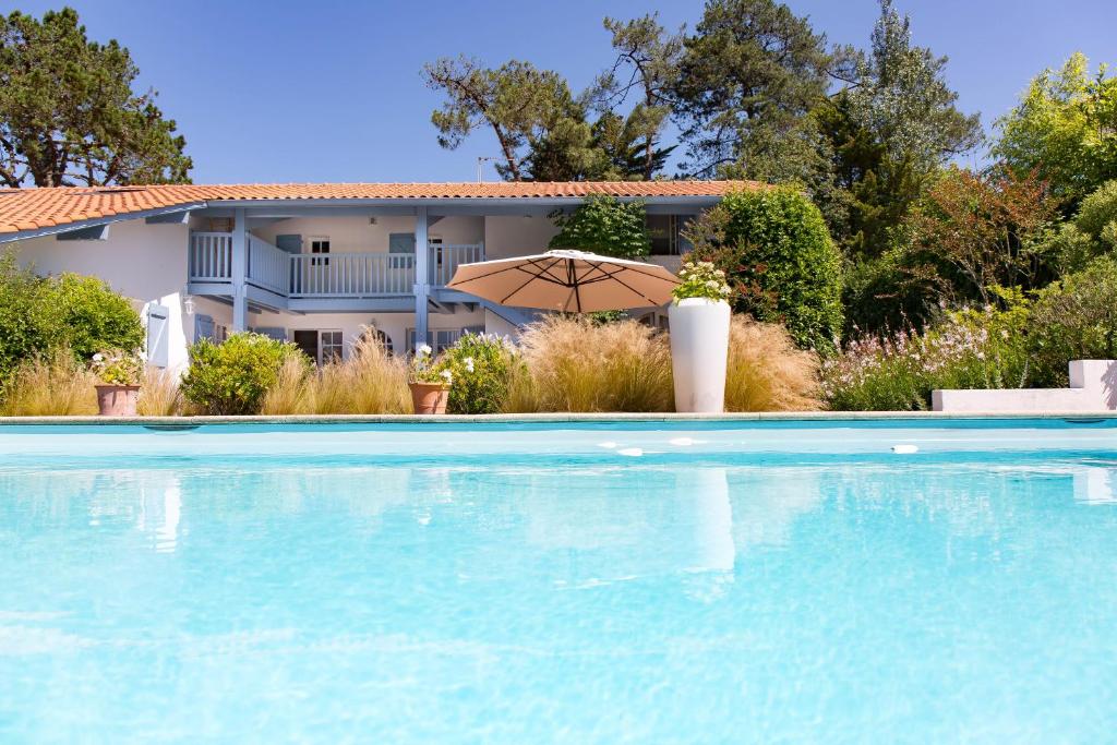 uma casa com piscina e guarda-sol em Chambre d'Hôtes Etchebri em Anglet