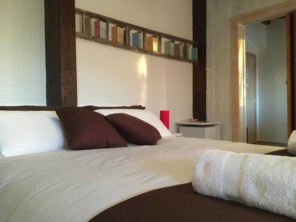 a bedroom with a bed with white sheets and brown pillows at Terra di Mezzo in Collepasso