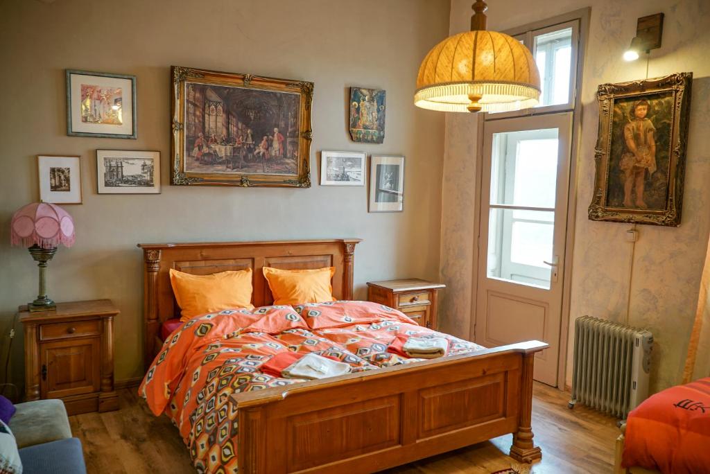 1 dormitorio con cama, ventana y cuadros en la pared en Rooster Hostel, en Veliko Tŭrnovo