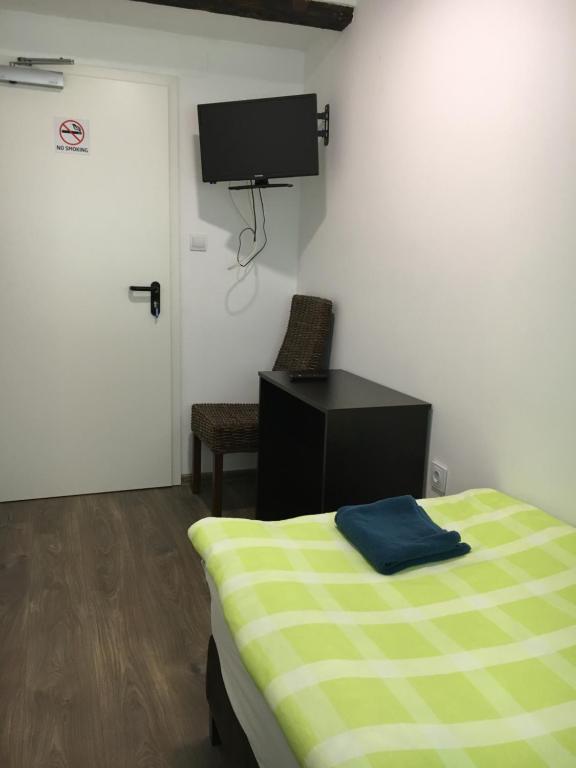 a bedroom with a bed and a tv on the wall at Pension Haus Baron 2 Friedrichsfeld in Edingen-Neckarhausen