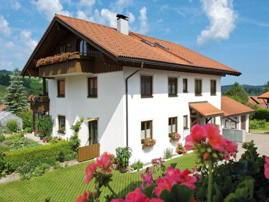 Casa blanca con techo rojo en Ferienwohnungen Wörner, en Oberstaufen