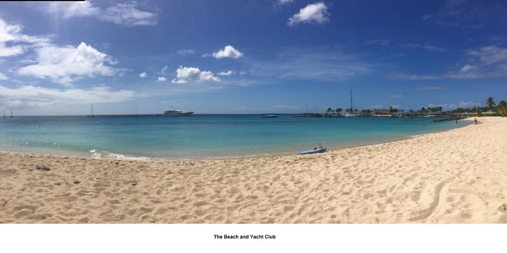 una spiaggia sabbiosa con una barca in acqua di Port St Charles unit 248 a Saint Peter