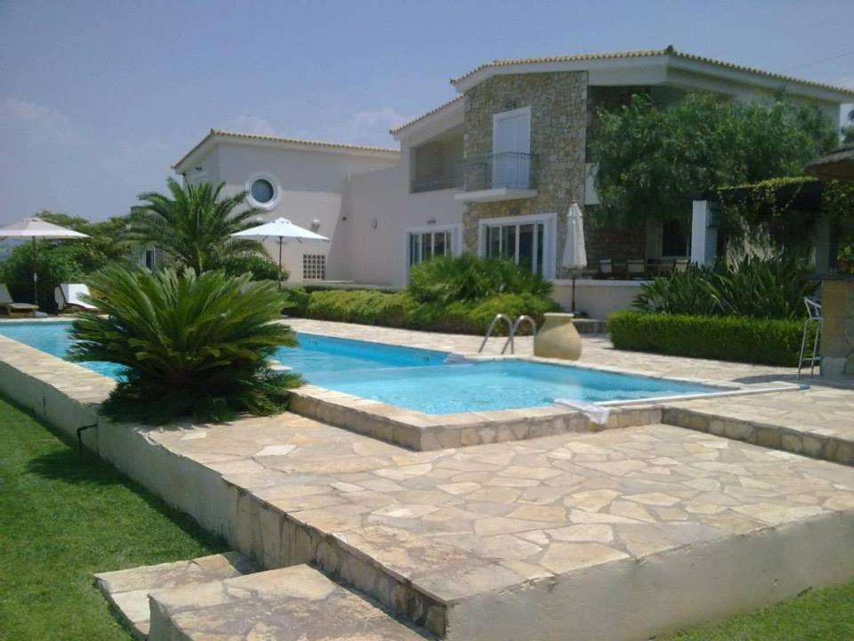a swimming pool in front of a house at Luxury Villa Flora Kiparissia in Kyparissia
