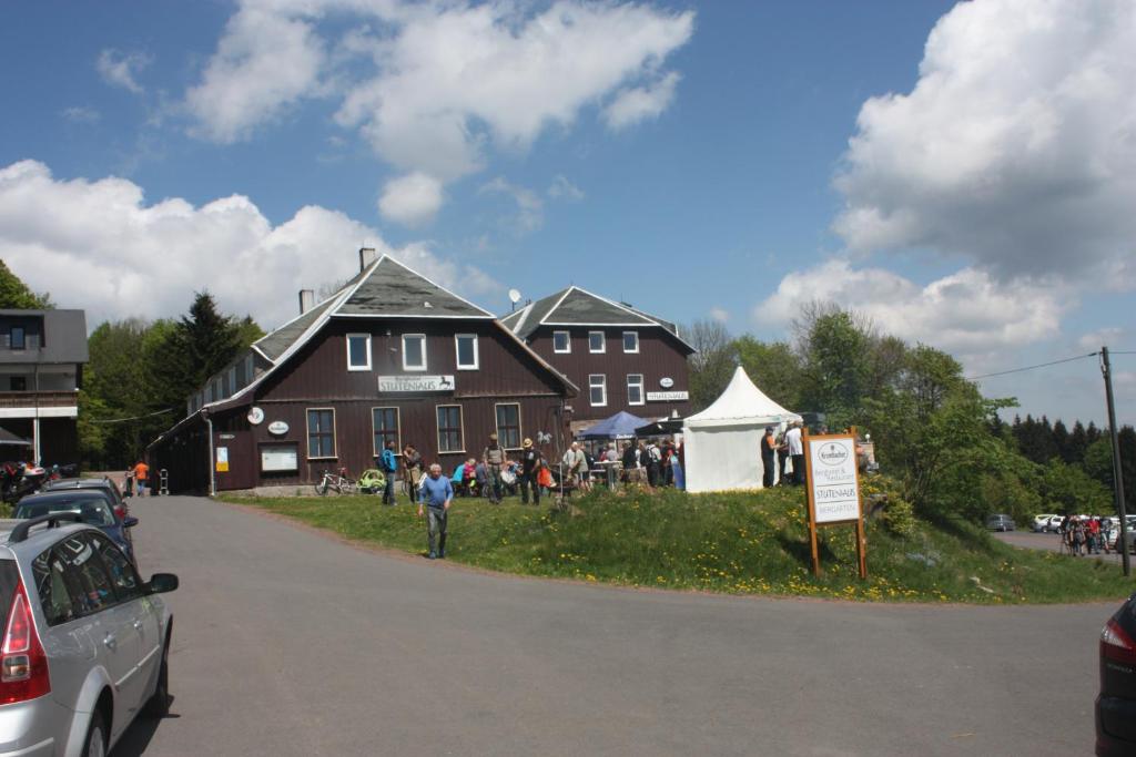 een groep mensen die voor een huis staan bij Berghotel Stutenhaus in Schmiedefeld am Rennsteig