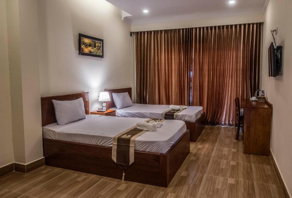 Postel nebo postele na pokoji v ubytování Phnom Penh Le Vincent Hotel