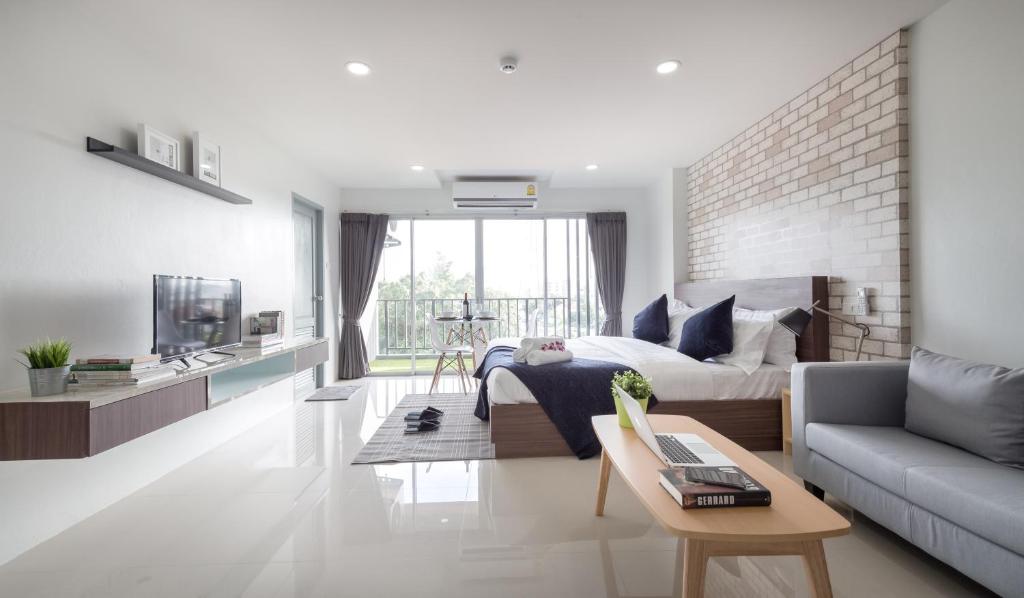 a white living room with a bed and a couch at Q Space Residence in Bangkok