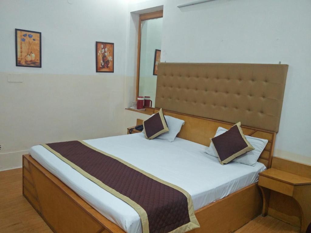 a bedroom with a bed with two pillows on it at Hotel Savoy - Since 1951 in Jaipur