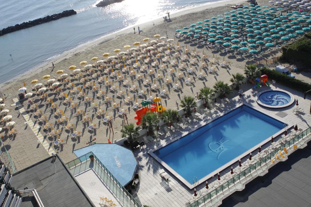 eine Luftaufnahme eines Strandes mit Sonnenschirmen und einem Swimmingpool in der Unterkunft Hotel Mediterraneo in Montesilvano