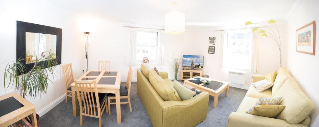 ノリッジにあるPerfect 2 bedroom apartment located in City Centre with parking spaceのリビングルーム(ソファ、テーブル、椅子付)