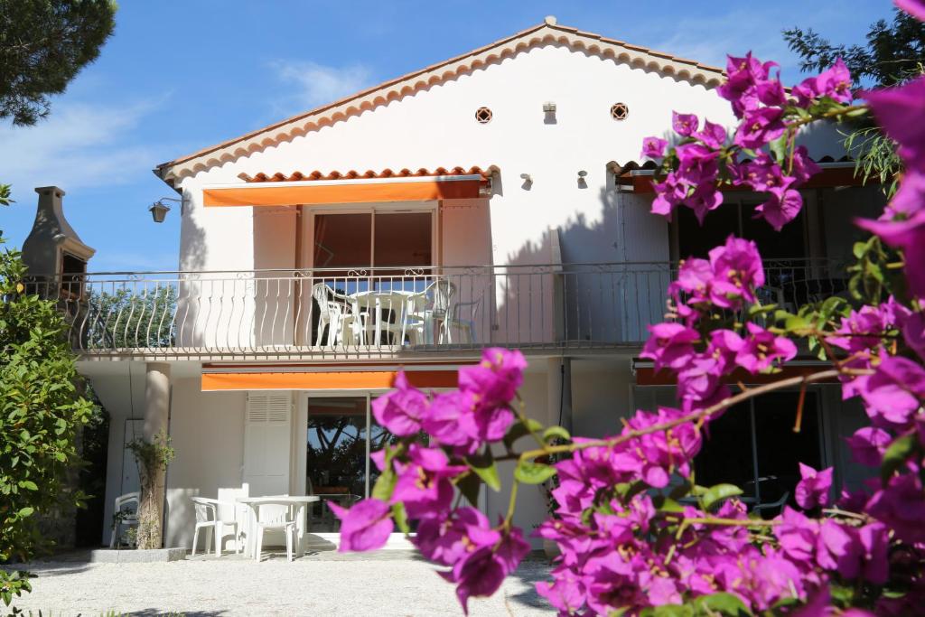 キャヴァレール・シュル・メールにあるLocation Corsicaの紫の花が咲くバルコニー付きの家