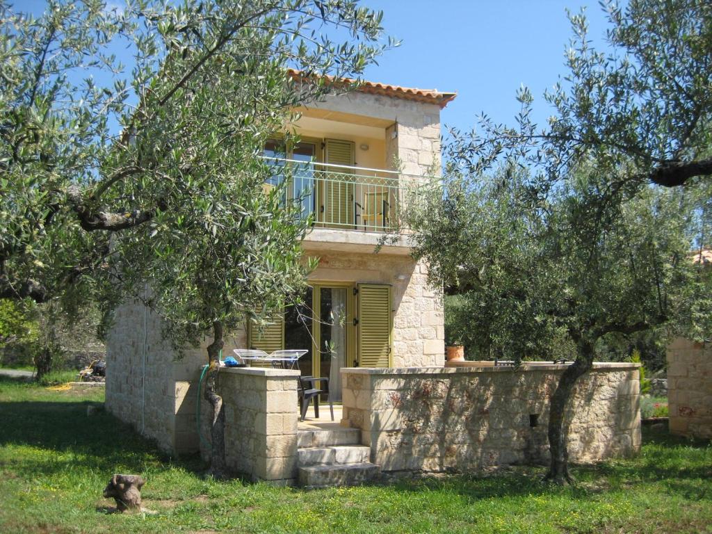 a stone house with a balcony on top of a stone wall at Amoni Holiday Homes in Kardamili