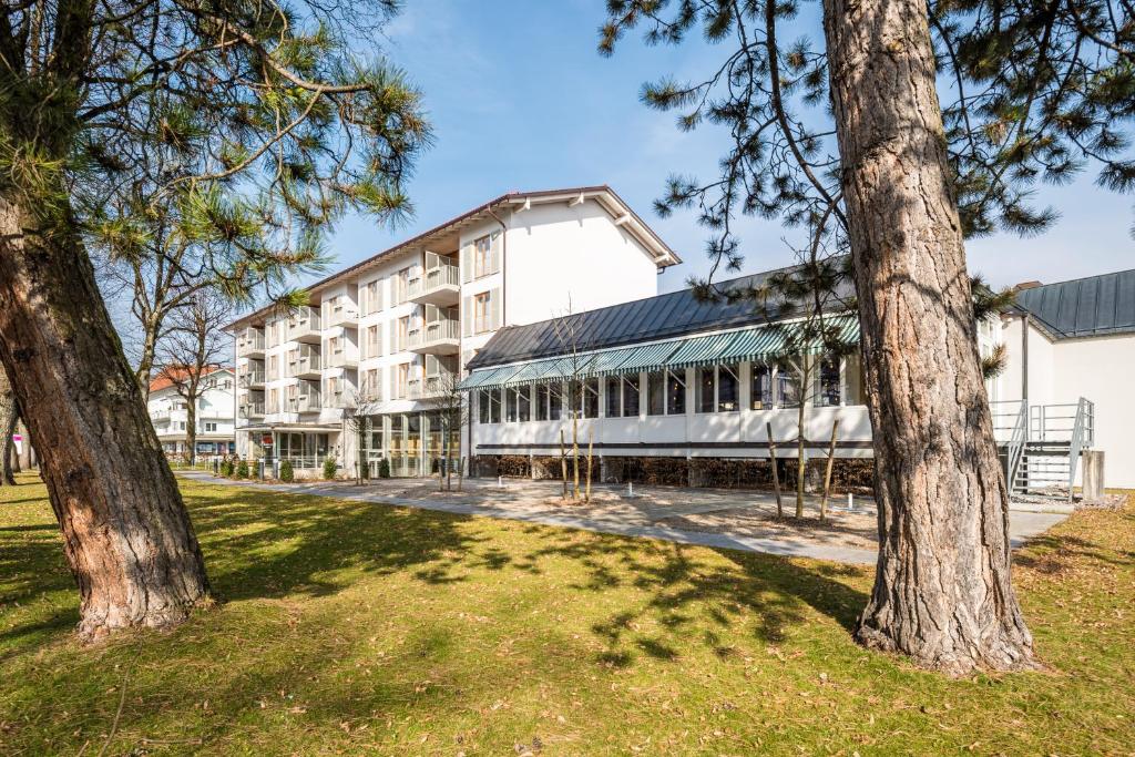 a large white building with trees in front of it at BSW Hotel Isarwinkel in Bad Tölz