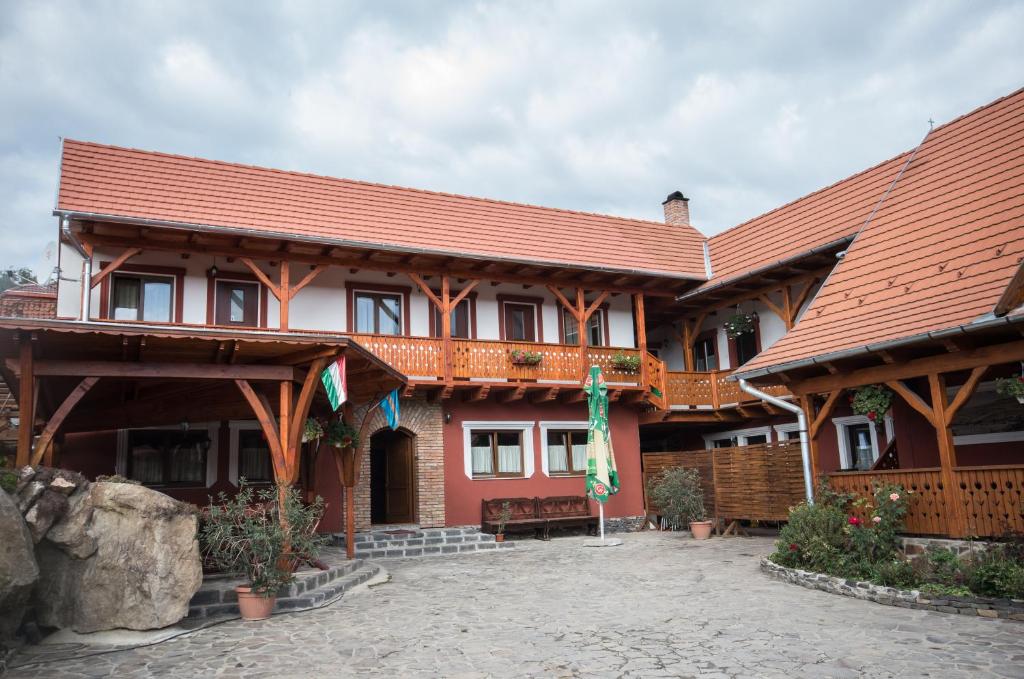 a building with a red roof with a courtyard at Sziklakert Fogadó in Sâncrai