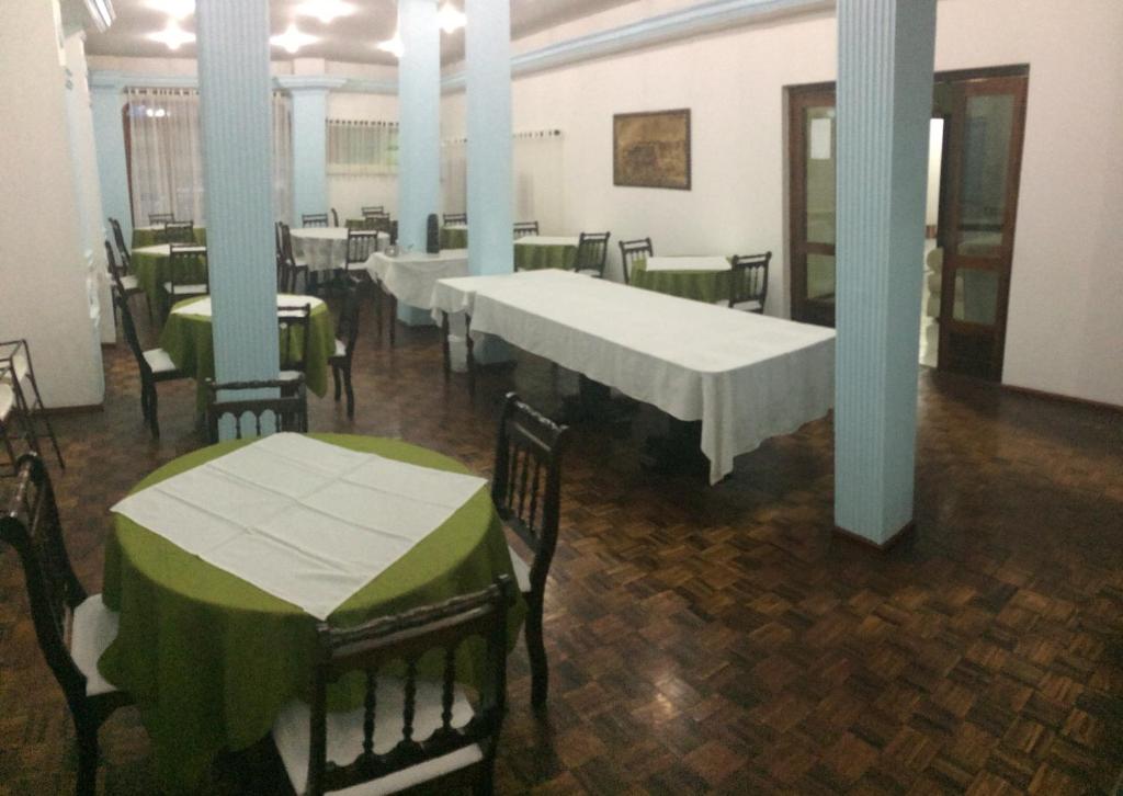 un comedor con mesas y sillas con manteles verdes en Hotel Tourist Araranguá, en Araranguá